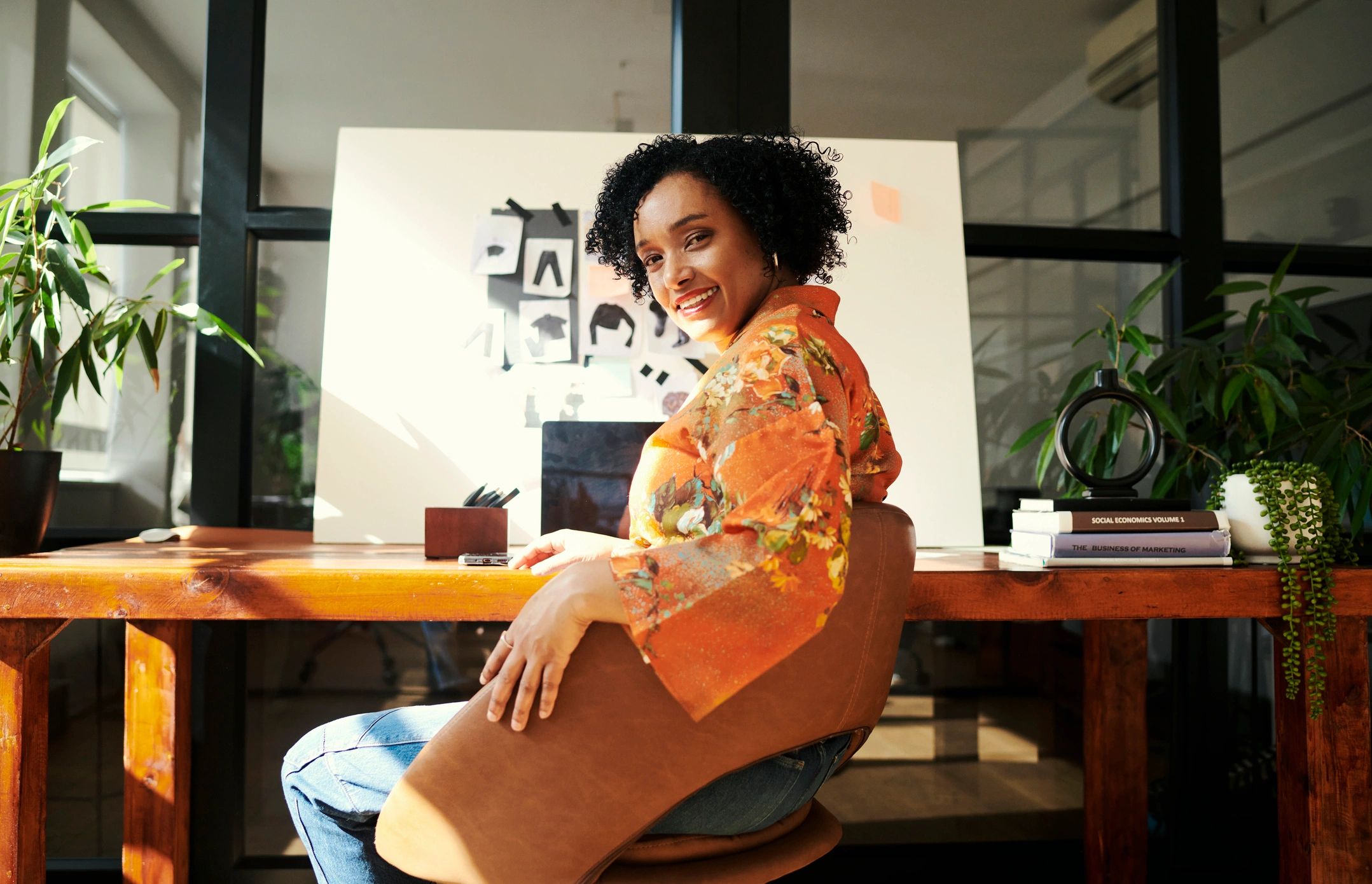 Writer seated at a studio desk with notes and creative materials