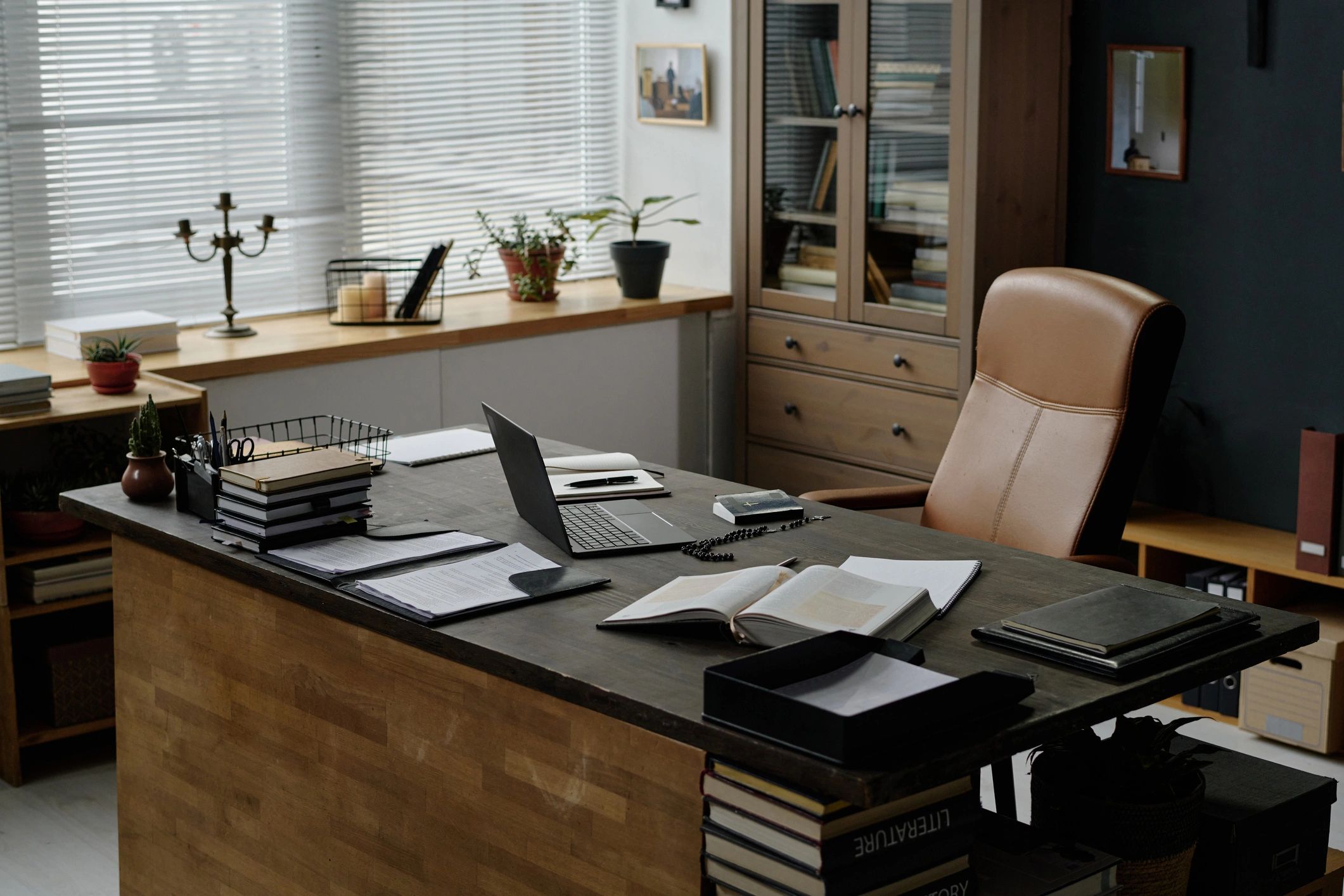 Desk with laptop, books, and notepads